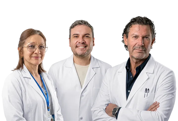 Three medical professionals in white coats posing together, smiling at the camera in a clinical setting.