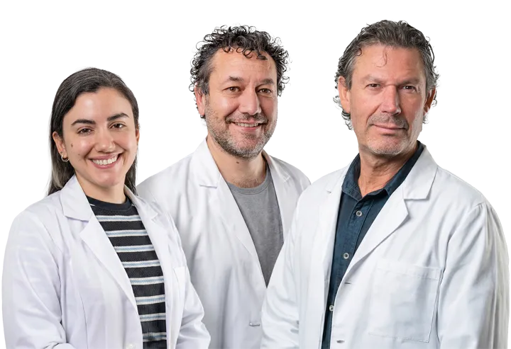 Three medical professionals in lab coats smiling at the camera.